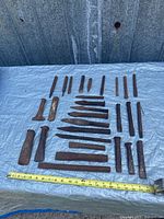 All chisels and punches laid out on tarp with measuring tape for scale