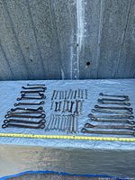Full layout of all wrenches on tarp with tape measure for scale