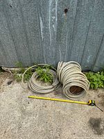 Two coils of braided vinyl hose beside tape measure
