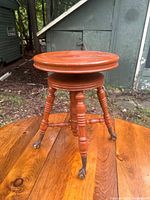 Full view of wooden organ stool on wooden surface outdoors