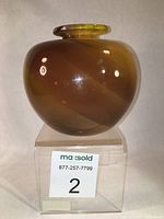 Front view of the bulbous blown glass vase showing amber gradients and smooth glossy surface.