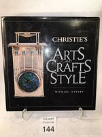 Front cover of the hardcover book showing the title 'Christie's Art and Crafts Style' with an image of a clock in Arts and Crafts style.