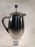 Front view of the stainless steel insulated French press showing the body, black handle, and plunger knob.
