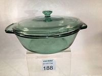 Green translucent glass casserole dish with lid shown from front angle on a white background.