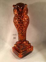 Front full view of the orange mercury glass owl sculpture, showing the entire figure and tiered base.
