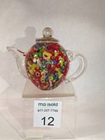 Front view of vintage style Murano glass teapot paperweight with vibrant millefiori canes visible inside the rounded body.