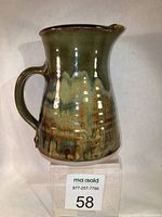 Front and side view of the Robin Hopper jug showing its earthy tone glaze and overall condition