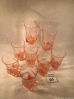 Photo showing the set of 8 pink swirl glasses together, highlighting the square base and the transition to the round opening.