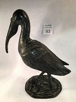 Full side view of pelican sculpture on white background