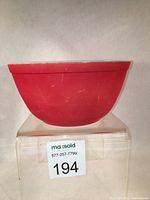Side view of the vintage red Pyrex mixing bowl showing exterior surface and shape.
