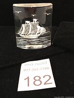 Front view of vintage Lucite paperweight showing schooner ship with detailed sails and birds.