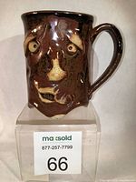 Front view of Wendy Parsons cheeky stoneware mug showing facial sculpted features with dark brown glaze and lighter highlights.