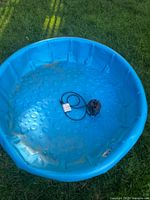 Blue plastic kiddie pool, showing textured bottom and slight dirt marks inside.