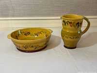 Serving bowl and pitcher set displayed side by side showing colors and decoration