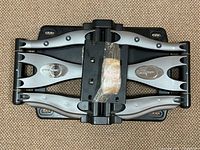 Top view of the Omni Mount wall mount showing articulated arms, metal parts, and pivot mechanism.