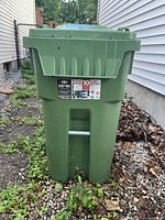 Front view of a green 95 gallon garbage bin with a Cart-Bac label and white handle on front.