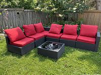 Assembled modular patio set with red cushions and glass-topped table outdoors