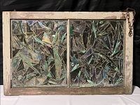 Front view of vintage stained glass hanging in wood frame with metal chain