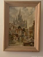 Front view of the framed oil painting showing the European cityscape with cathedral, boats, and canal.