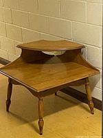 Front view of a vintage mid-century modern wooden step end table with a two-level stepped top and four turned legs in medium brown finish.