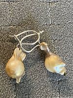 Front view of vintage drop earrings with silver fishhook closures and baroque pearls showing natural uneven shapes and glossy surface.