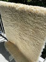 Full view of ivory wool pad draped over railing