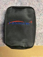Black zippered carrying case with Konnwei logo embroidered in red and blue thread on front.