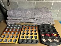 Photo showing three muffin pans stacked: two 24-cup mini muffin pans and one 6-cup jumbo muffin pan