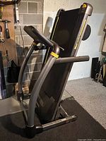 Treadmill in folded upright position showing frame and folding design.