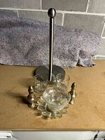 Full set of miscellaneous kitchen items including paper towel holder, two small glass cups, two silver-tone salt and pepper shakers, and a textured glass candle holder dish.