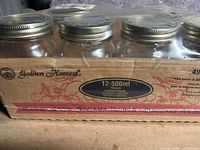 Box with eight empty mason jars, Golden Harvest brand, 500 ml size indicated on package