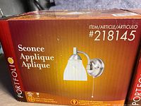 Box with front image of Portfolio wall sconce, showing model number 218145, with sconce image and branding