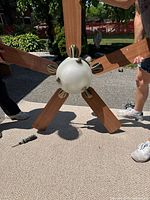 Front view of 5-blade ceiling fan showing frosted glass light fixture with metal accents and two-tone wooden blades.