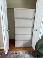 Front view of the beige filing cabinet closed, showing five equal-size drawers and lock on the top drawer.