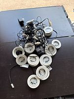 Overview of multiple Dals LED linkable under cabinet lights with cables and power adapters on black surface.