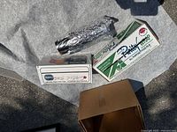 Photo showing two boxes of plastic wrap, one new and one partially used, with a partially used roll of aluminum foil unboxed.