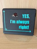 Black iPad Pro 12.9 keyboard case with a fabric cover showing a humorous printed graphic text "YES, I'm always right!" in blue and a small arrow/graph design