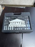 Closed Jobmate branded black plastic case with clear lid showing sockets inside