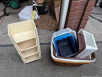 Photo of beige plastic stackable storage bin unit and various plastic laundry baskets stacked and nested.