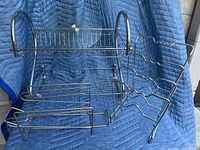 Photo showing multiple chrome finish metal kitchen organizers including a 2-tier dish rack, can organizer with roller, pot and pan rack, and lazy Susan.