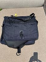 Photo of folded navy blue Samsonite travel garment bag showing front pocket, adjustable shoulder strap and Samsonite logo.