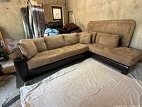 Full view of two-piece L shaped sectional sofa showing fabric cushions and leatherette base and armrests.