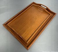 Two teak trays nesting together, showing wood grain, rectangular shape, and handles