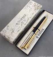 Original Parker box with gold and black Parker pen and matching mechanical pencil inside.