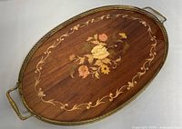 Full top view of the oval vintage marquetry tray showing floral inlaid wood design and brass trim with handles.