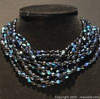 Front view of the multi-strand choker highlighting the iridescent black and blue beads.