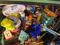Photo showing multiple cleaning supply items together including Resolve stain remover bucket, 3M and Weiman spray cans, Lysol wipes, Swiffer refills, microfiber cloths, and hand cleaning tools on a green metal cart.