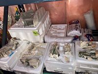 Porcelain figurines and packaging foam trays laid out, showing multiple wrapped nativity figures in plastic and foam packaging with fake snow bags visible.