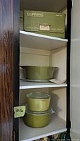 Three Pyrex bowls and original Corning box on shelf, showing full set and packaging.