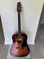 Front view of Montana sunburst acoustic guitar showing body, neck, and missing B string